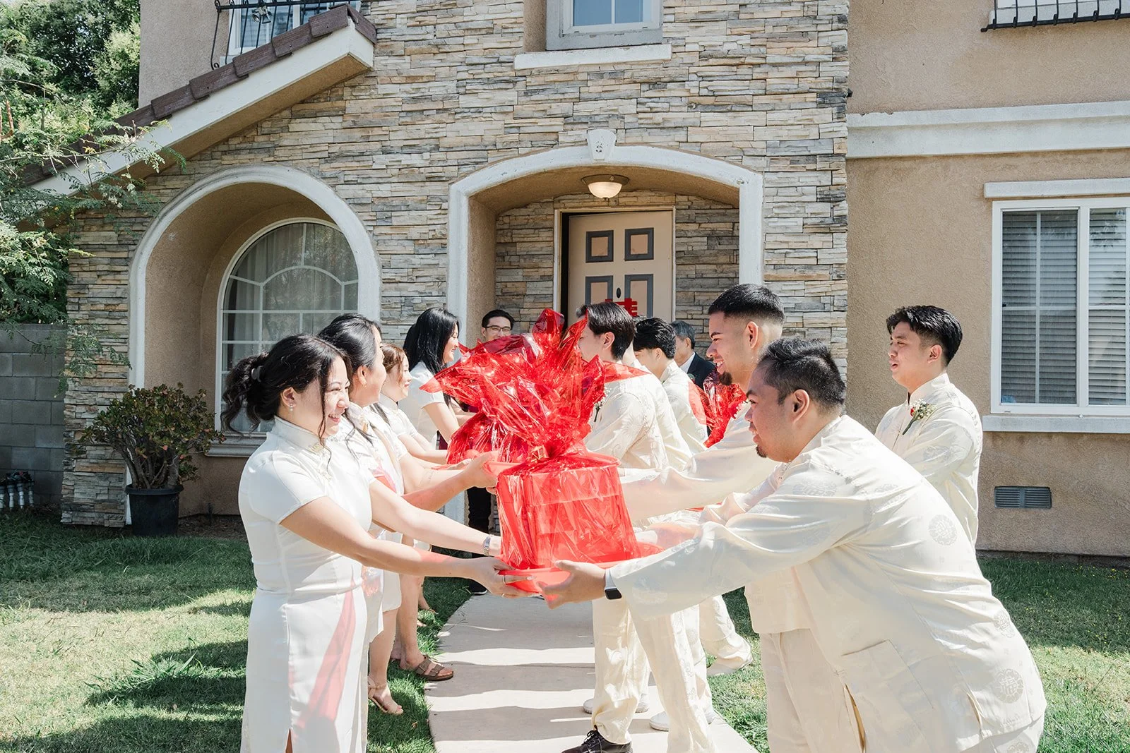 Groomsmen handing trays to the bridesmaids at the entry.