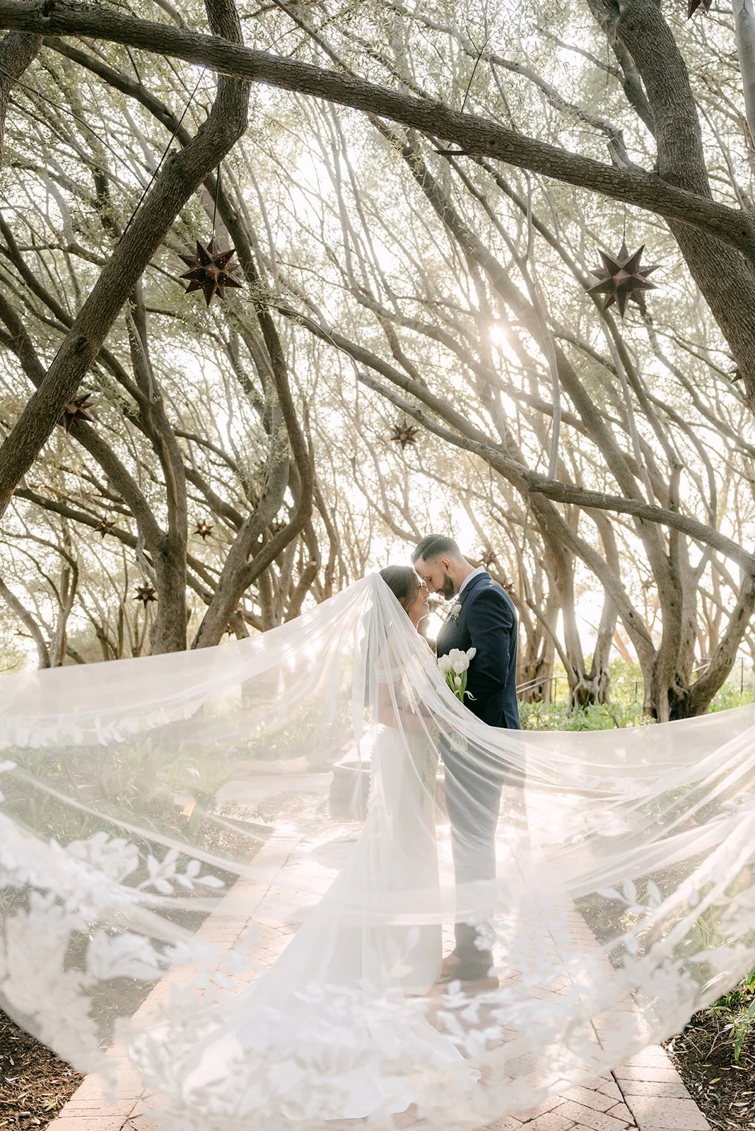 Mariana's cathedral veil spread across the path in front of the couple