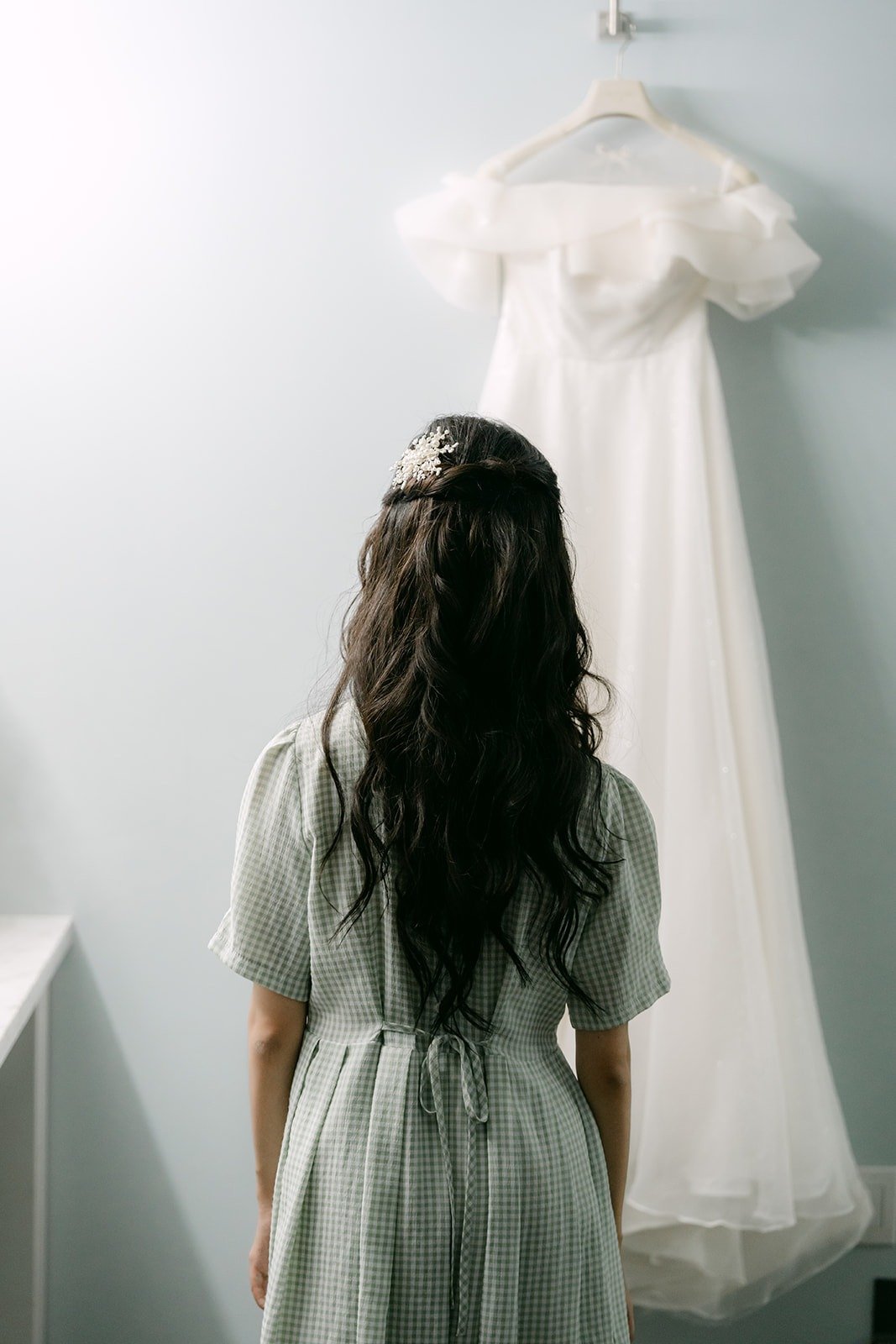 Jeannie looking at her gown from behind, her hair in soft waves