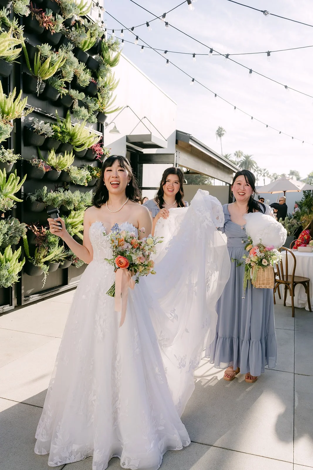 Vivian with her bridesmaids on the patio under string lights
