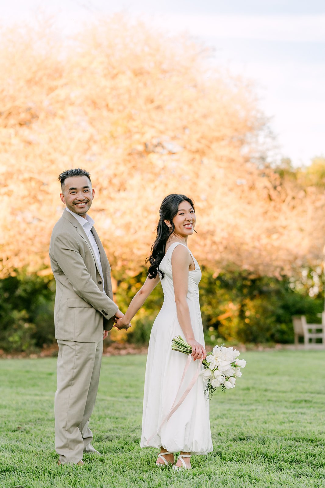 Kim and Vincent smiling on the lawn in golden light.