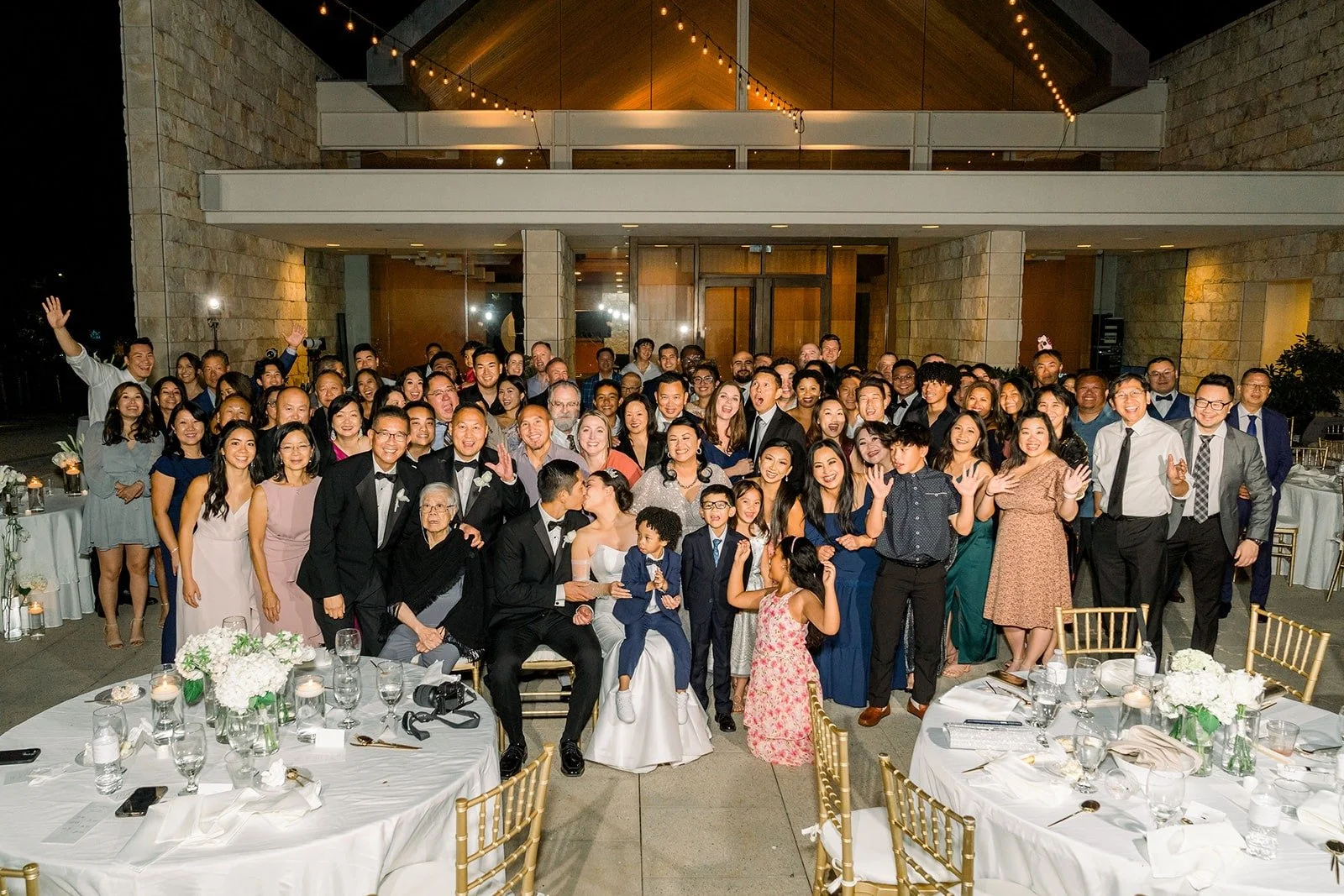 A big group photo of guests with Steven and Jacinda at night