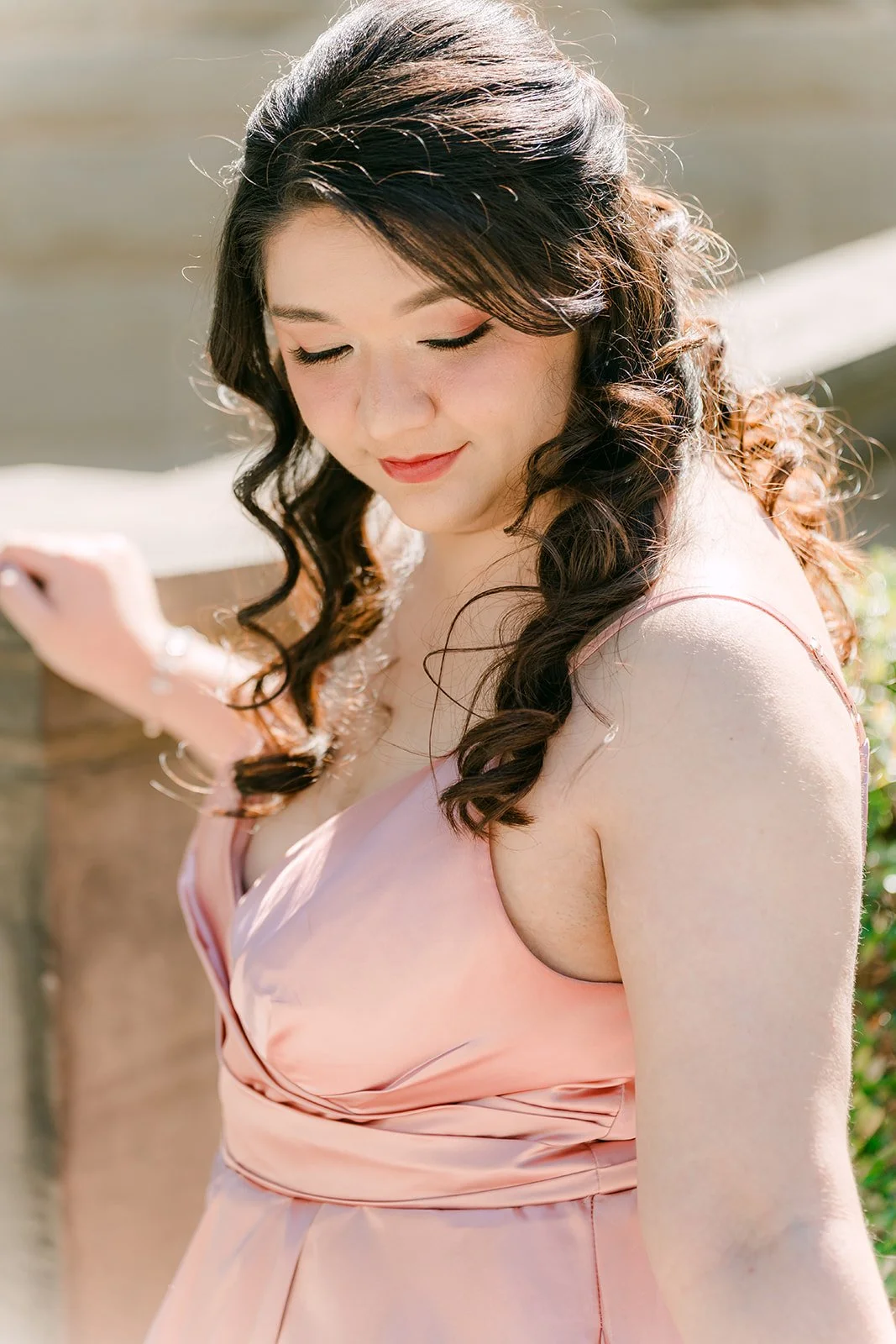 Close portrait of Saira looking down, her curls over one shoulder.