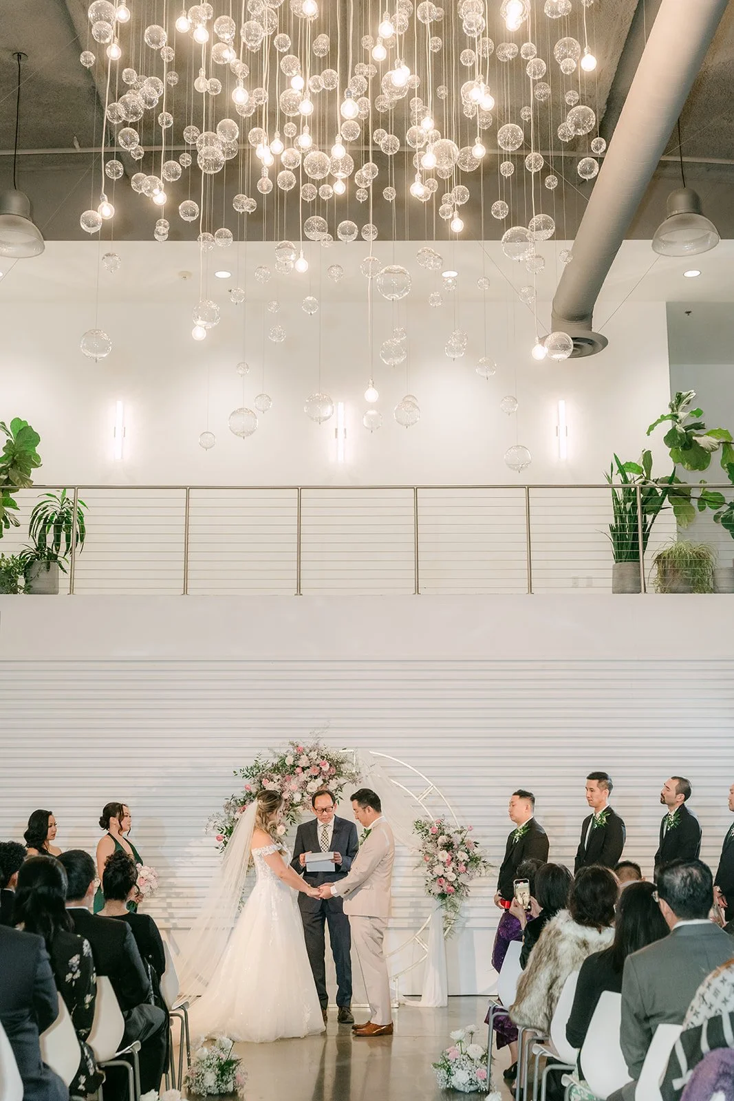 Ceremony under the hanging glass chandeliers at The Modern