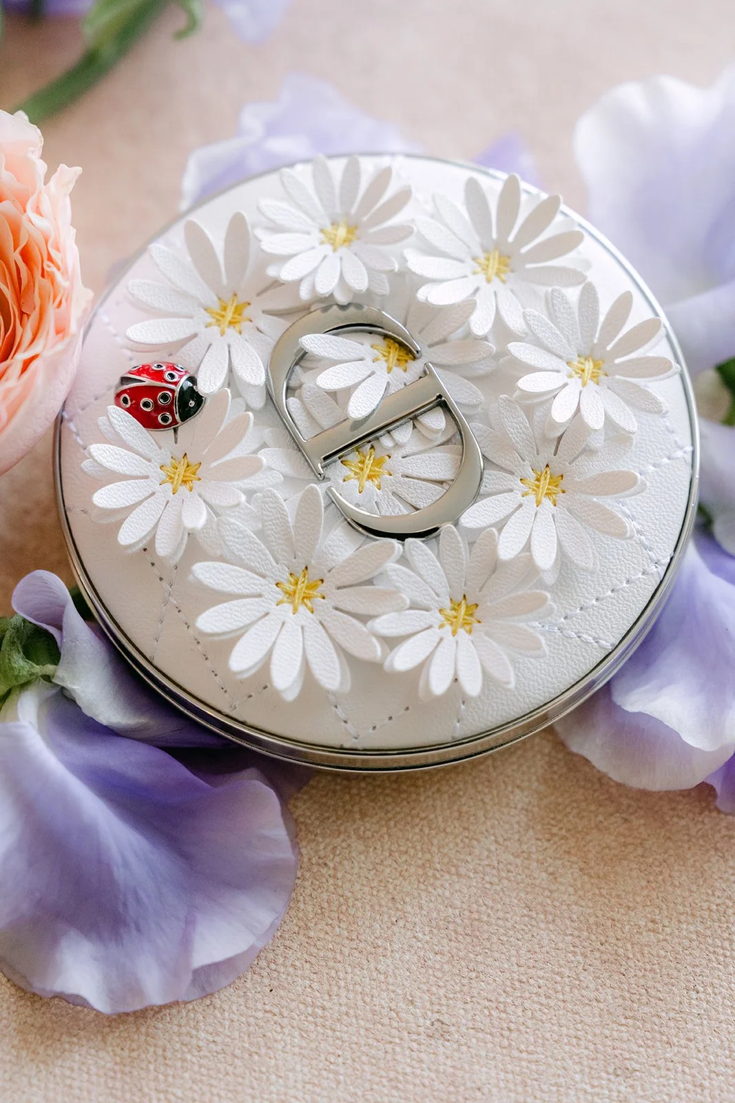 Wedding rings resting in a ring box covered with tiny white daisies.