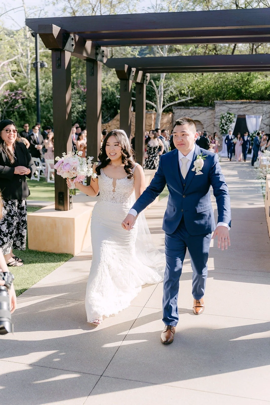 Kelli and Alex cheering under the pergola after the recessional
