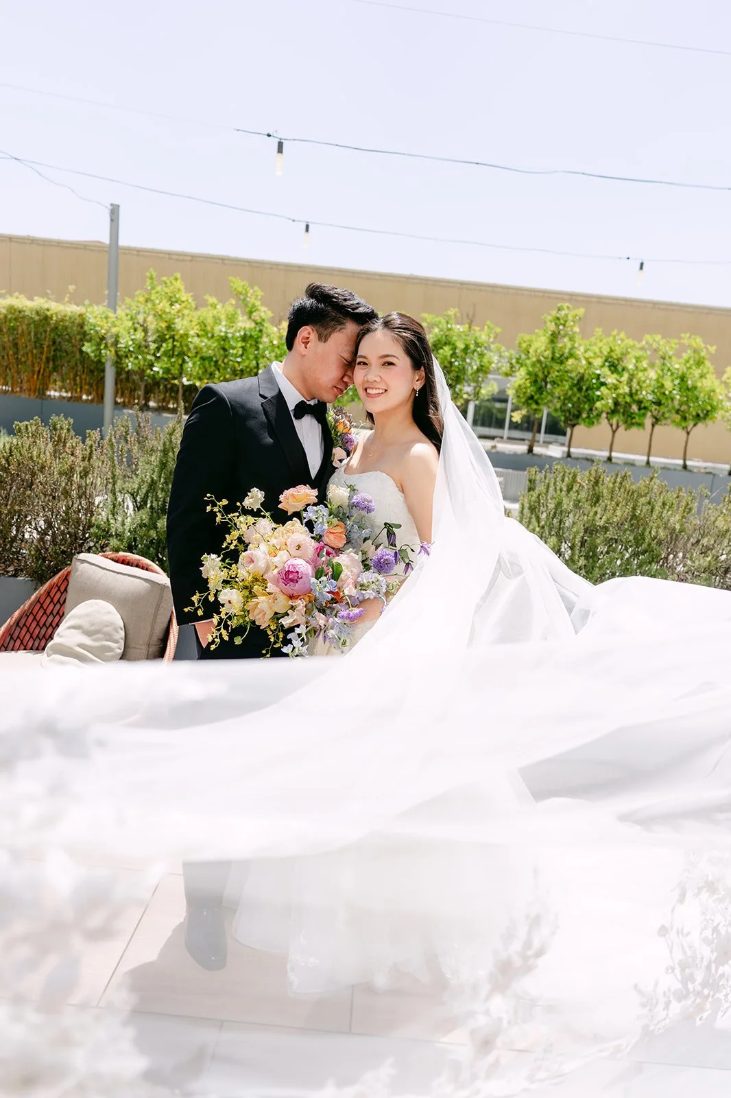 Linh and Hoan sharing a quiet moment as her long veil sweeps across the terrace