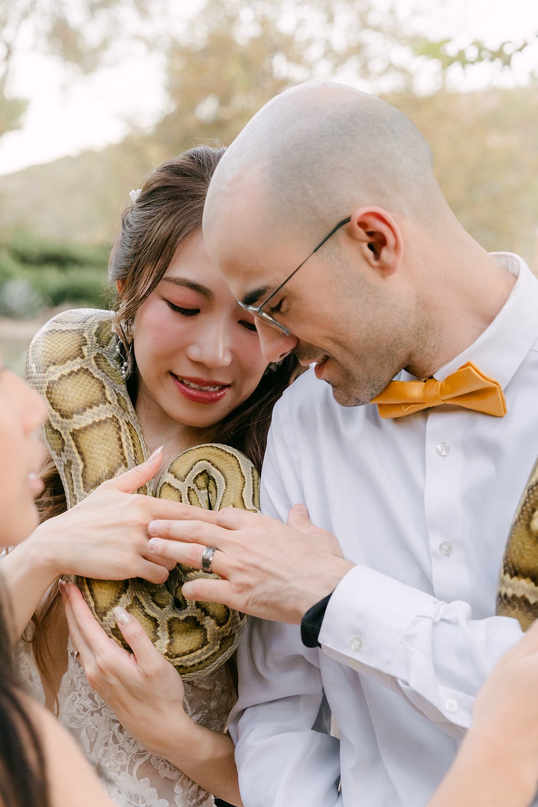 Christie and Christian cuddling a snake at their wedding, photographed by One and Only Production.