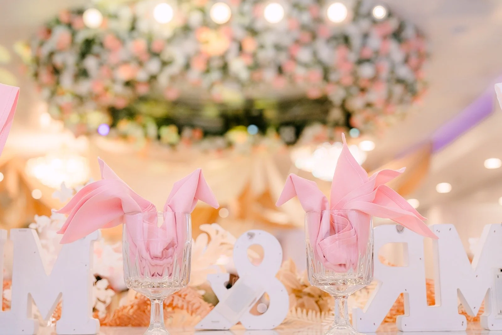 Pink floral centerpieces lining the head table