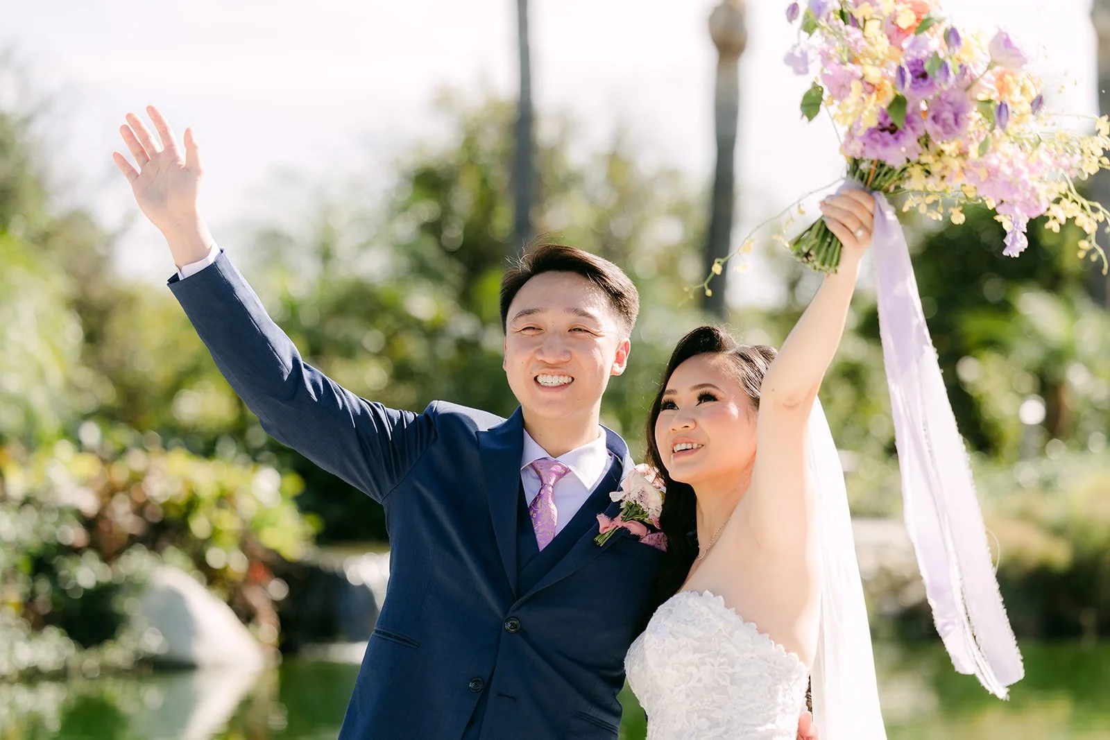 Vannie raising her bouquet as she and Elijah cheer, photographed by One and Only Production.
