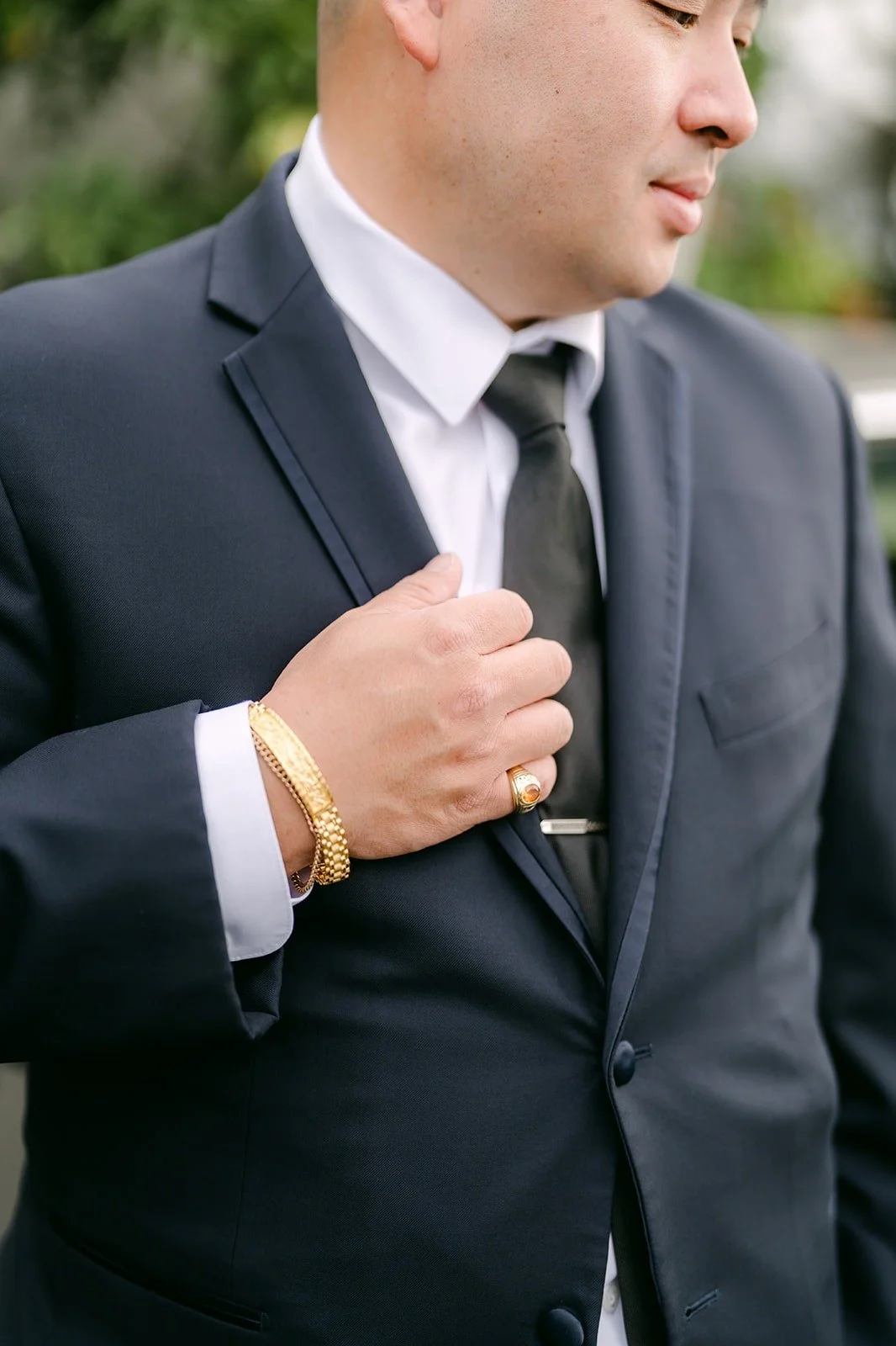 Yao adjusting his tie in a navy suit