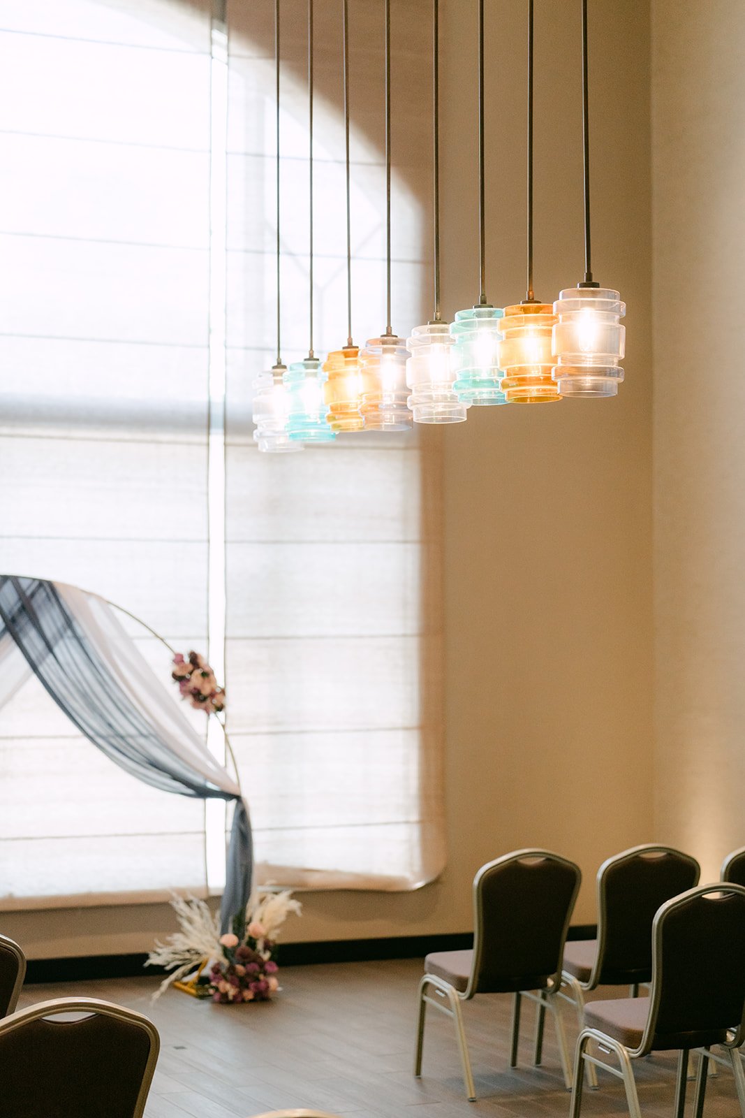 Colorful pendant lights over the ceremony chairs.