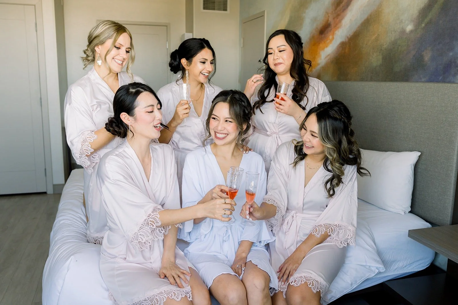 The bridesmaids gathered around Josephine in the suite, photographed by One and Only Production