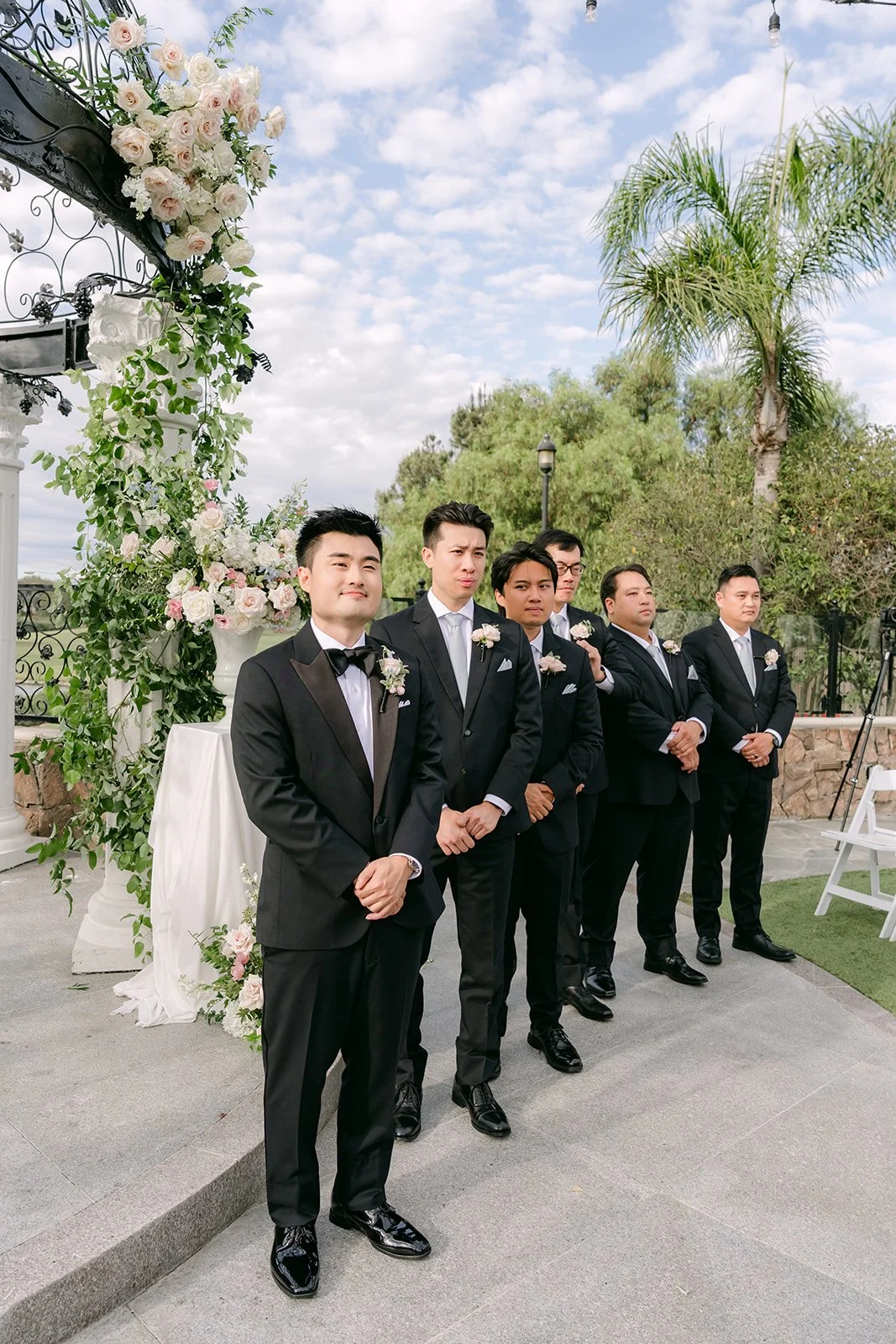 Kenny and his groomsmen beside the floral arch