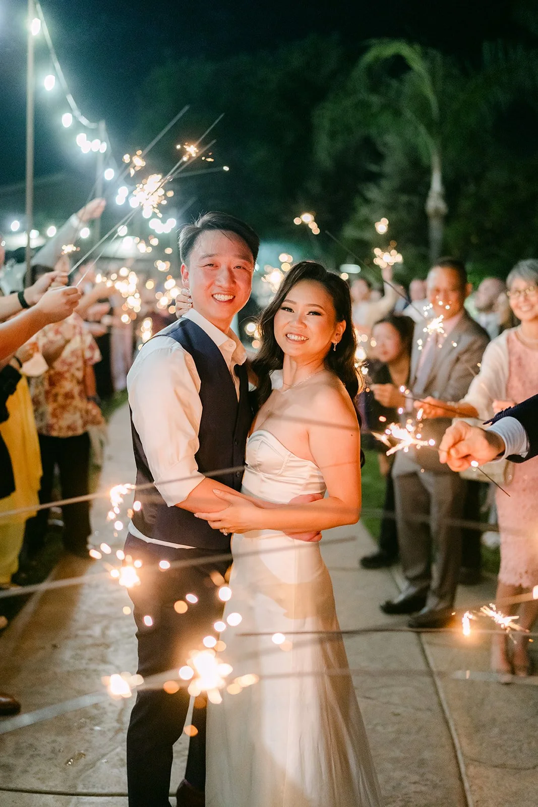 Vannie and Elijah smiling during their sparkler send-off, photographed by One and Only Production.