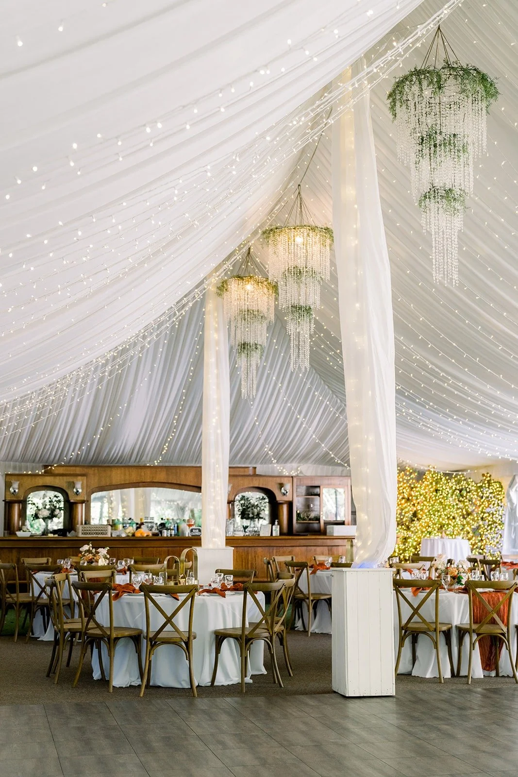The reception tent at Twin Oaks set with wooden tables