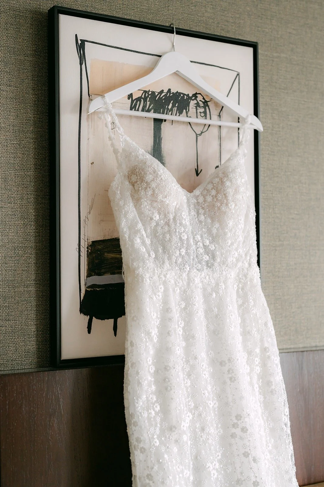 Kristine's lace wedding gown hanging in the hotel suite