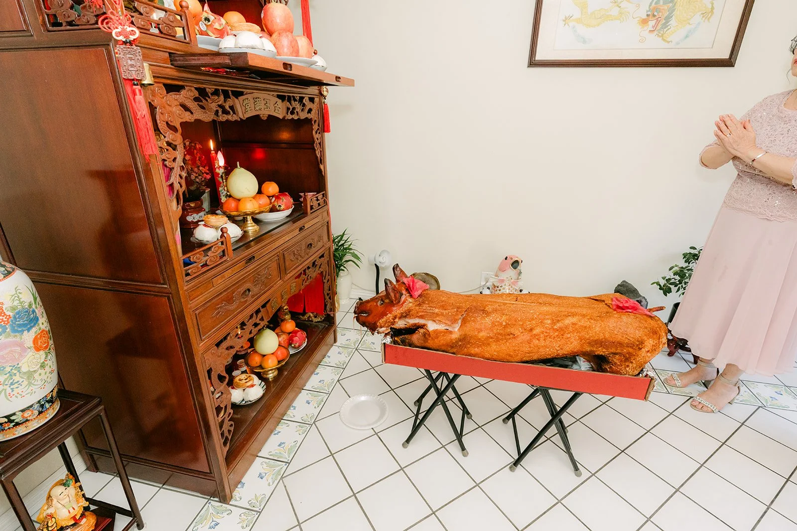 A roast pig and gifts beside the family altar.