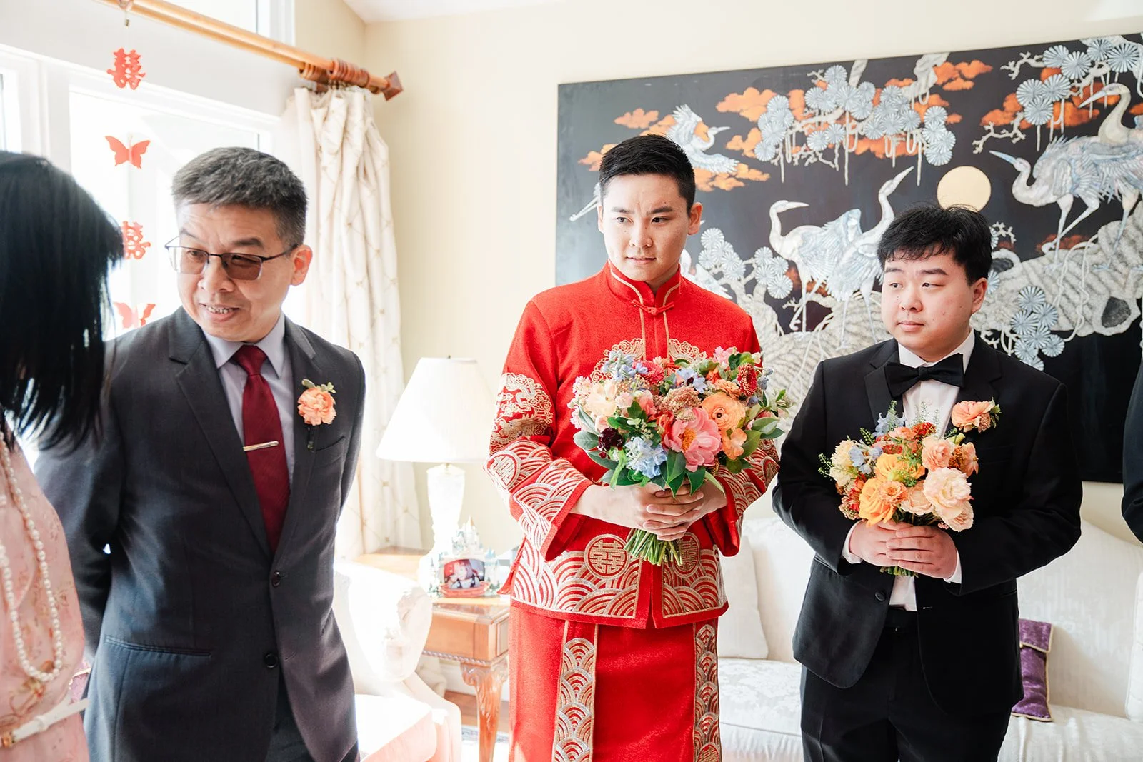 Henrik and his groomsmen waiting in the hallway with bouquets.