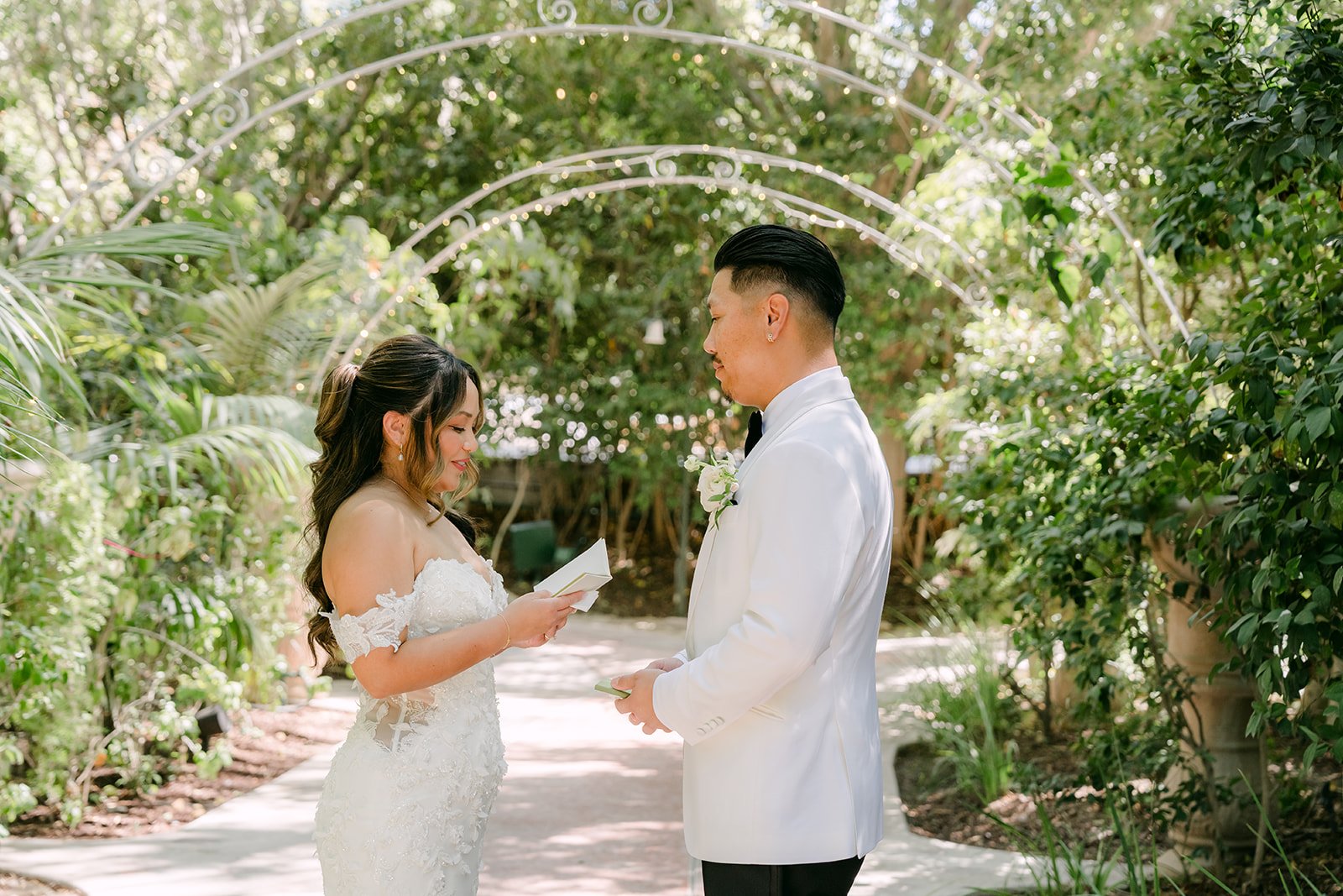 Nicole reading her personal vows to Caryl under the garden arches at Eden Gardens.