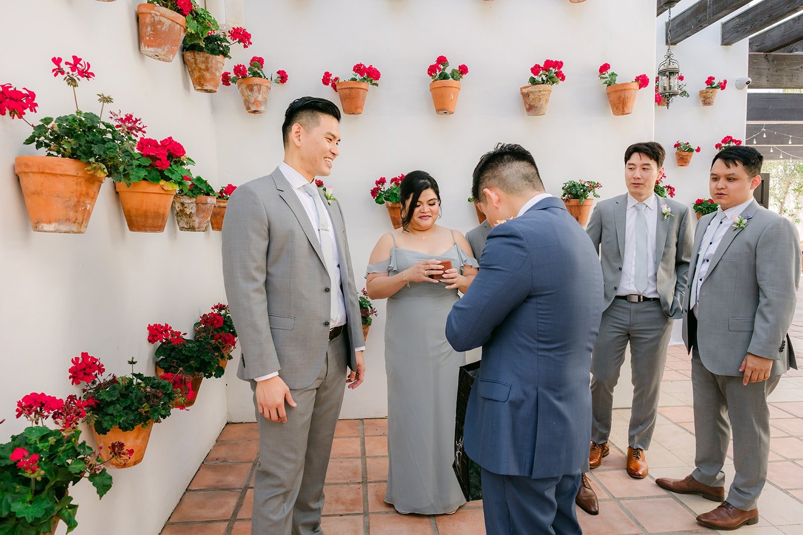 Jerrick with his party in light gray in front of the geranium wall