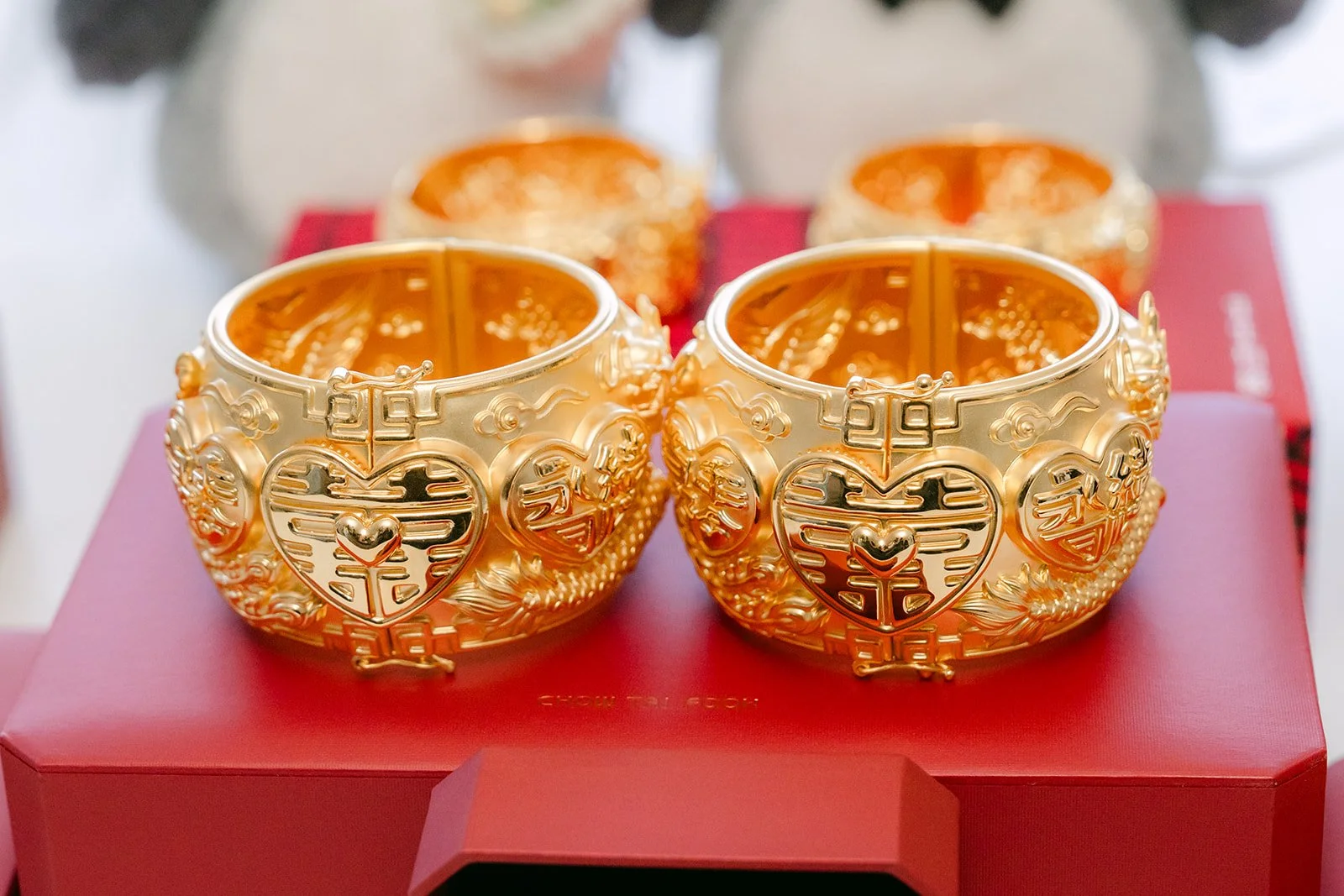 Gold bangles in red boxes laid out for Christie and Christian's tea ceremony.