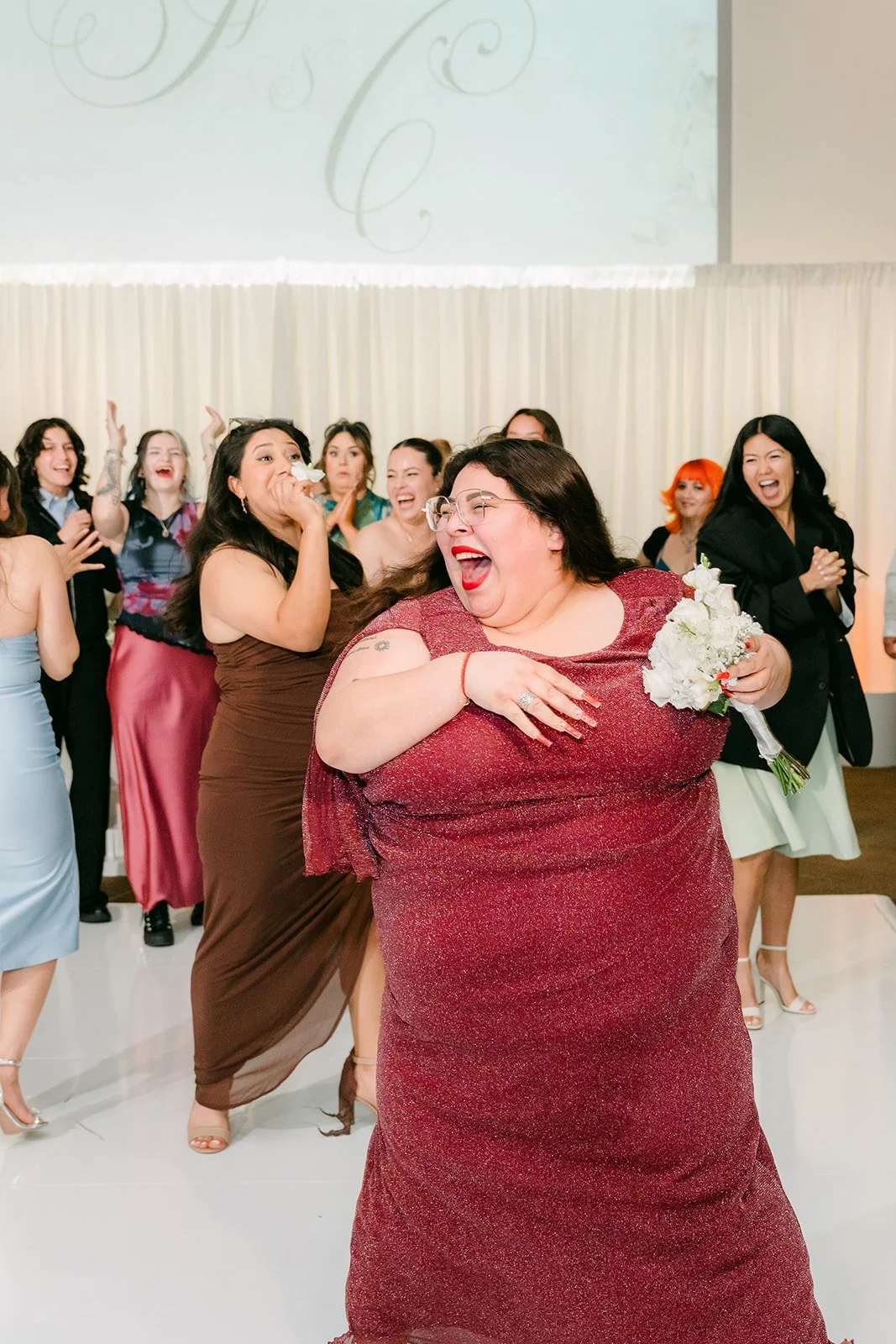 A guest celebrating after catching the bouquet.