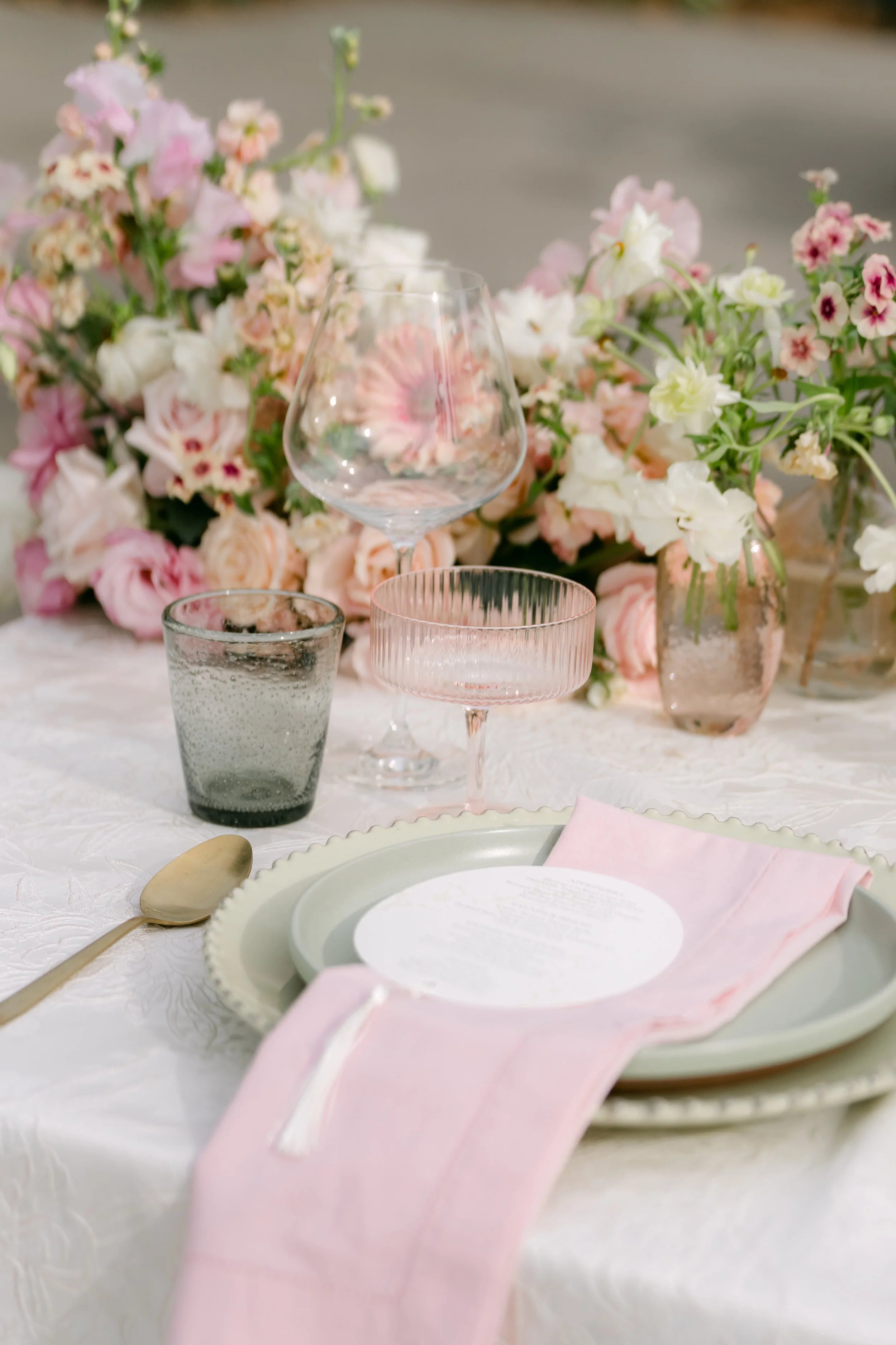 Place setting with a pink napkin and blush florals at Monserate Winery