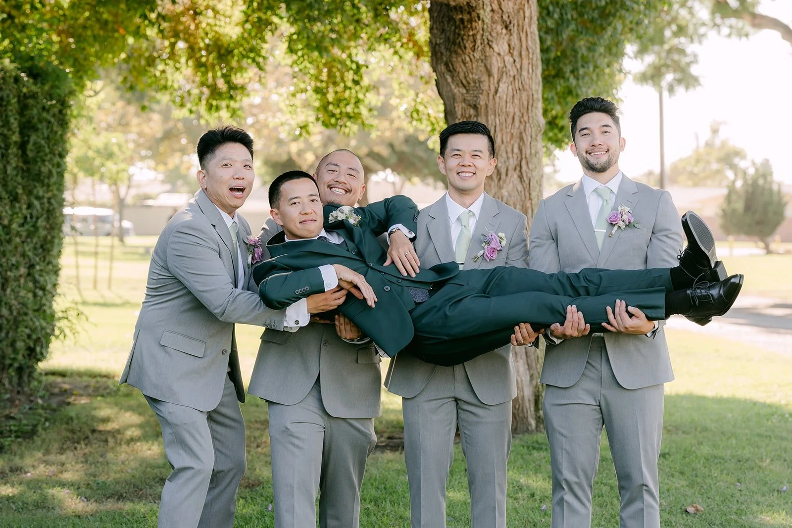 Kevin's groomsmen carry him sideways for a fun photo