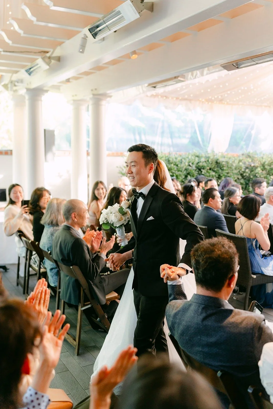 Guests clapping as the newlyweds walk past