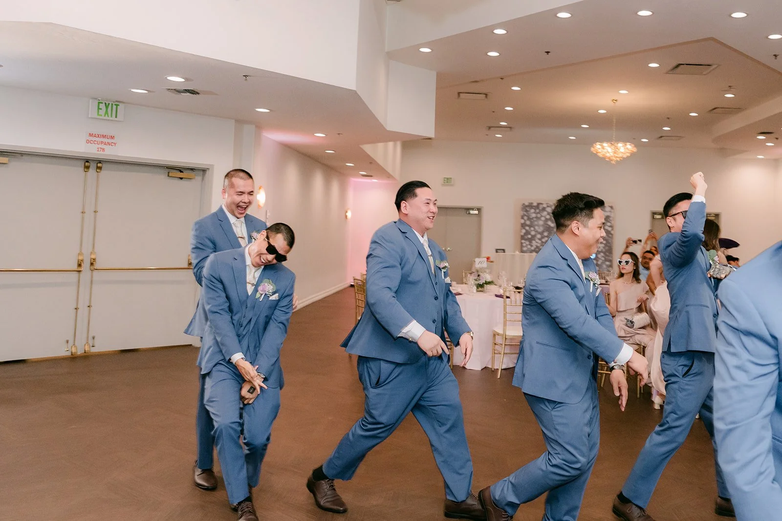 The groomsmen dancing in a line during the grand entrance.