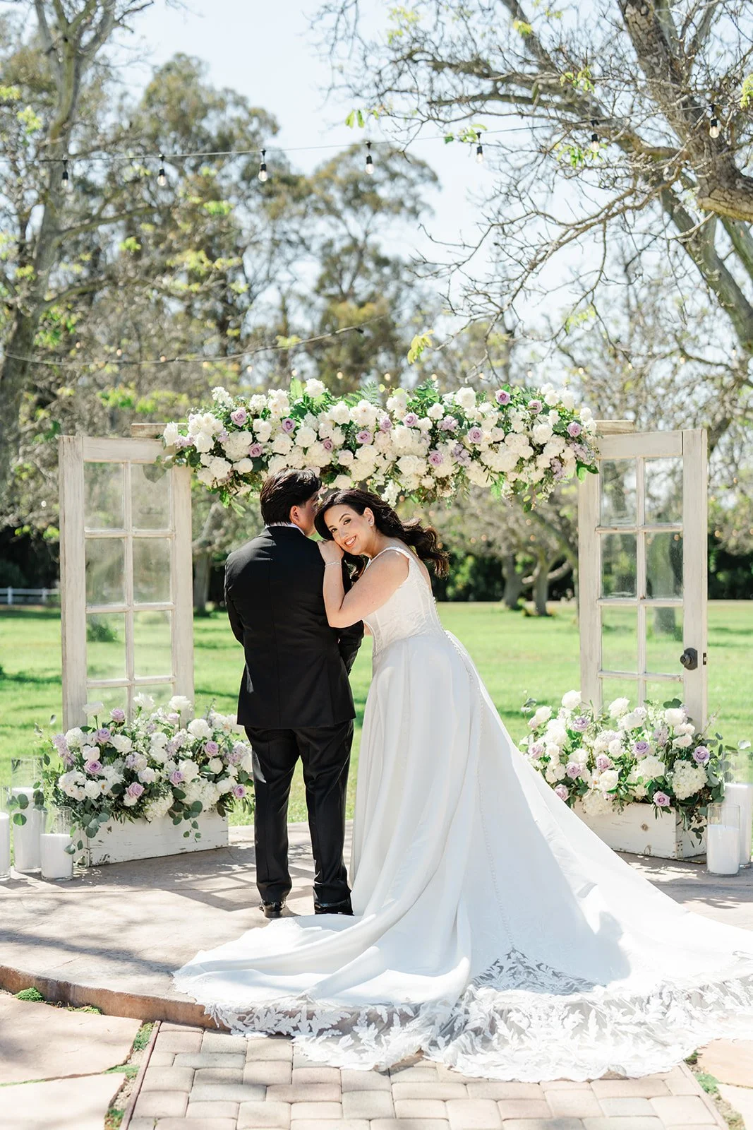 Couple embracing at the ceremony arch