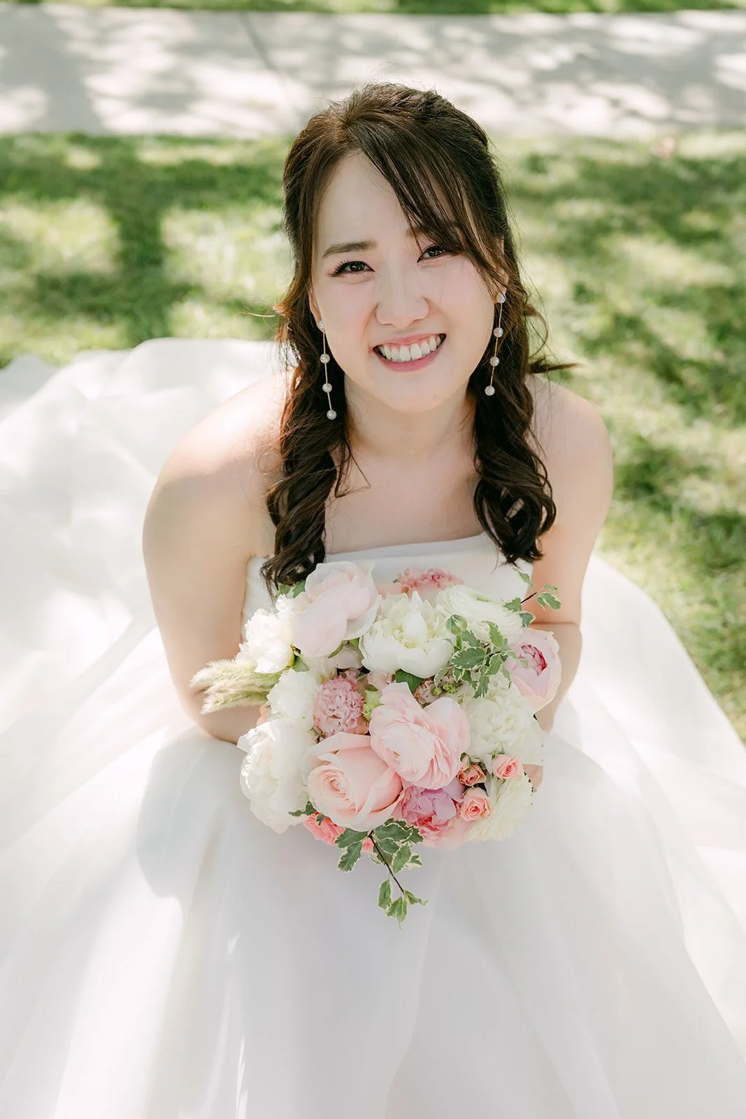 Judy smiling with her bouquet on the lawn
