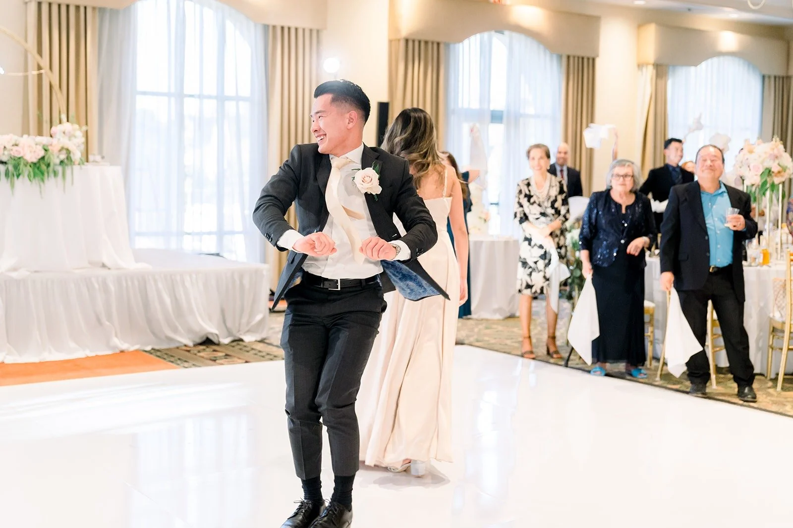 A groomsman spinning on the dance floor during the grand entrance