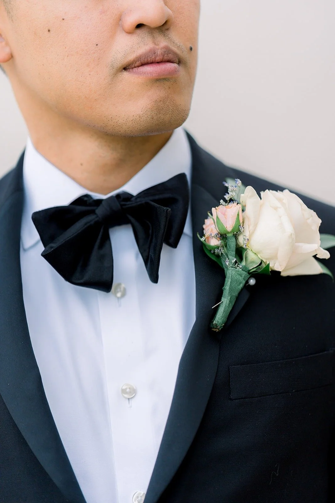 Close up of Ralph's velvet bow tie and white rose boutonniere