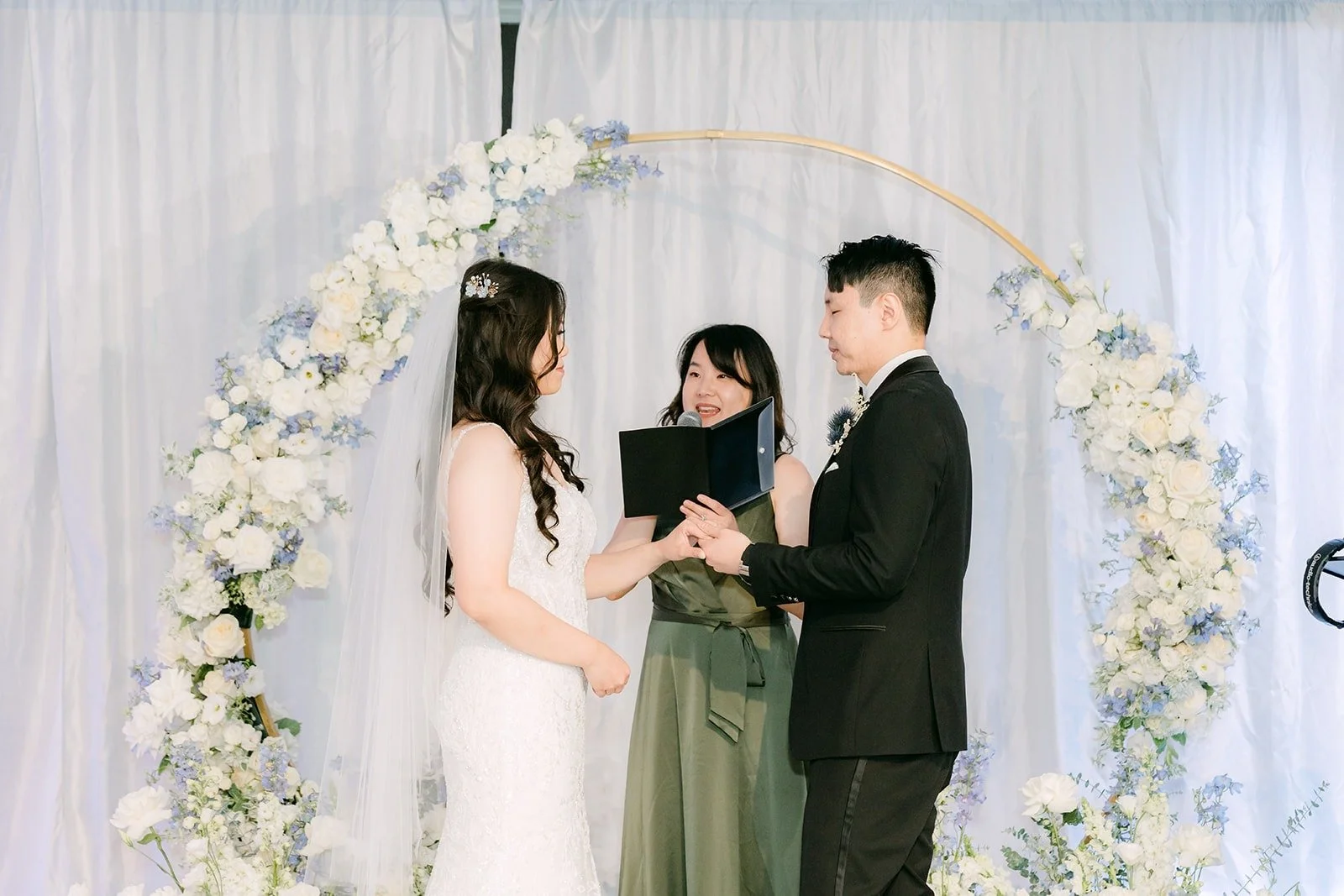 Wide view of the ceremony at the floral arch