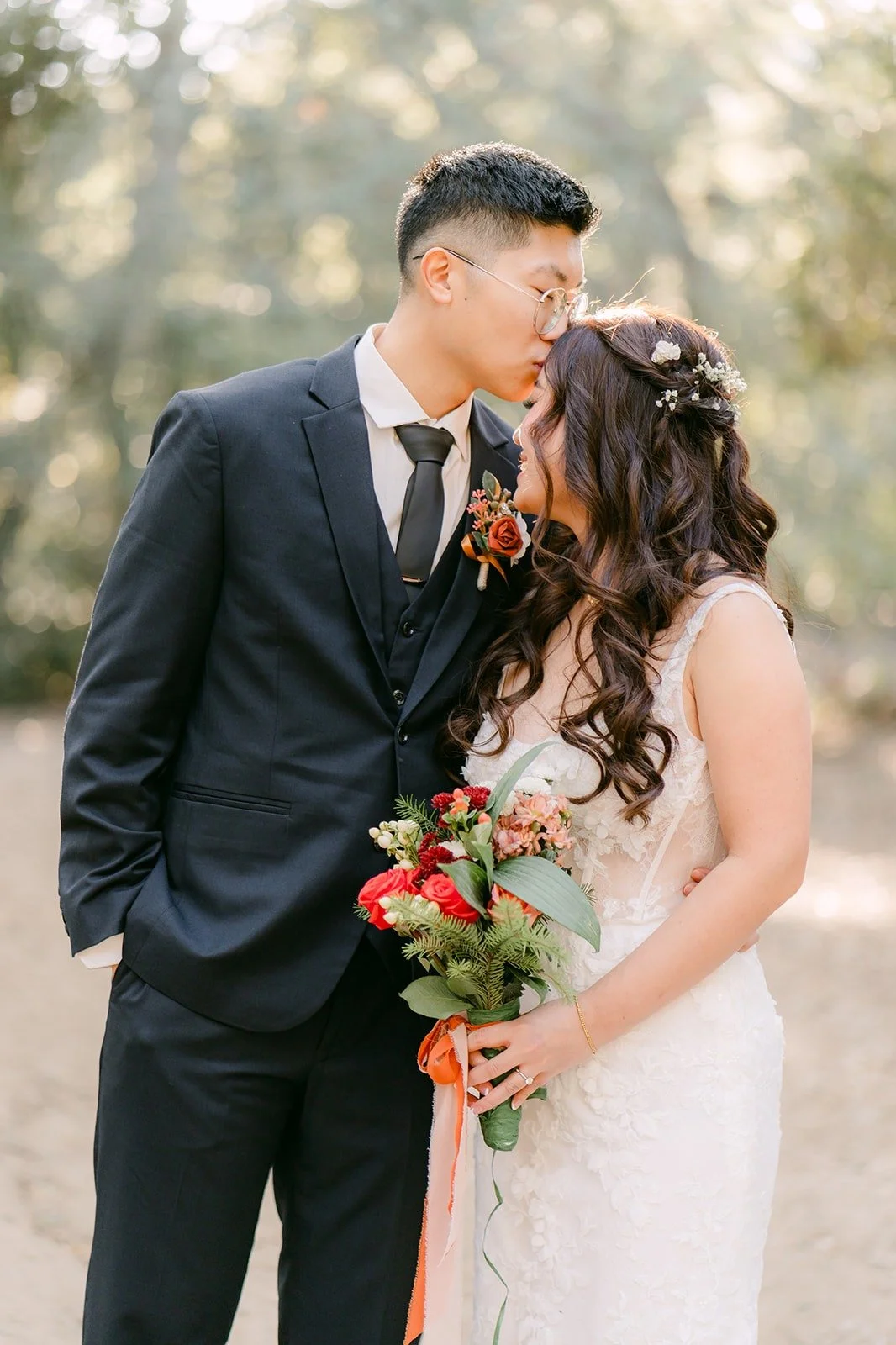 Robert kisses Shayna's forehead among the oaks