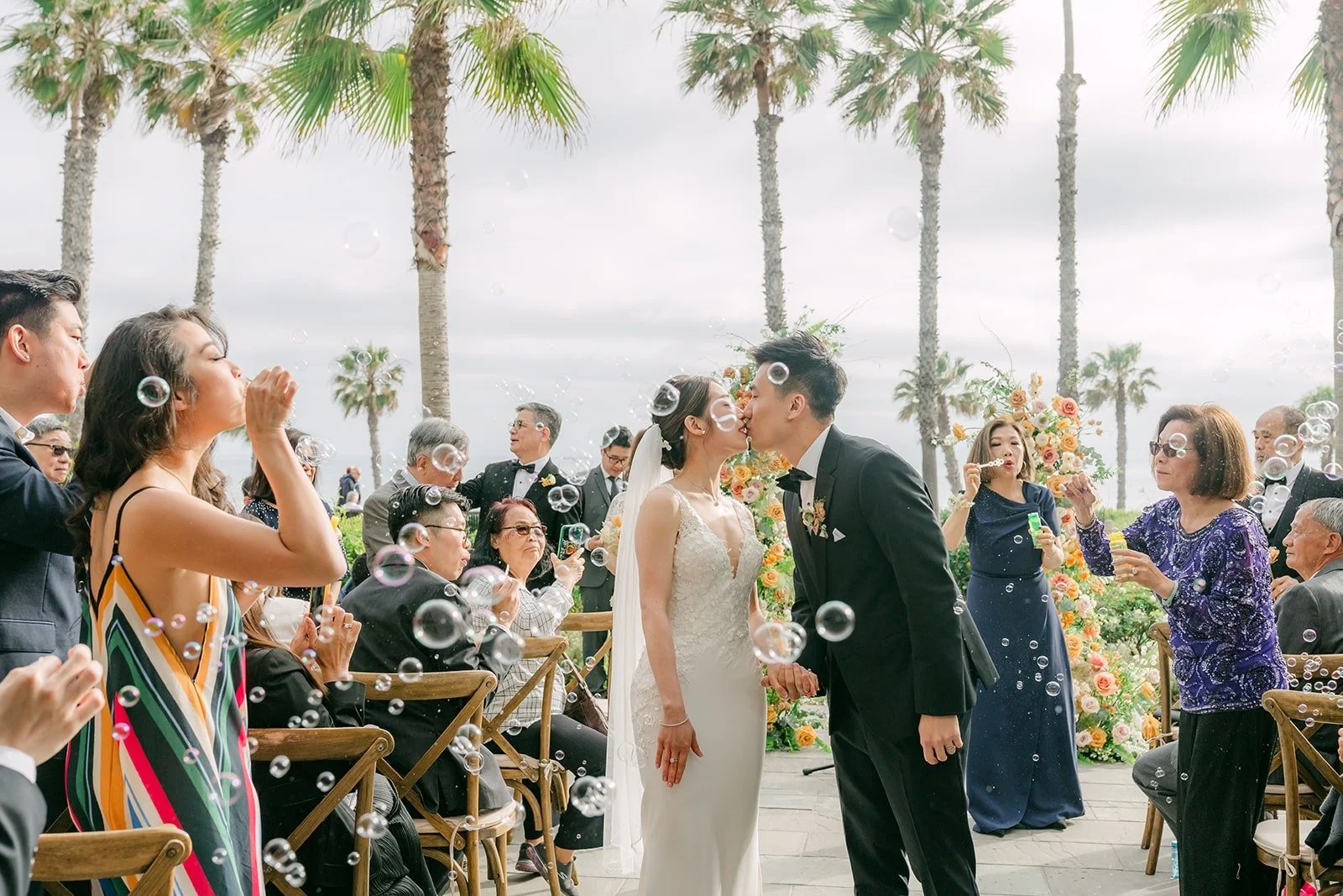 Angela and Eli walking back up the aisle as guests celebrate, photographed by One and Only Production