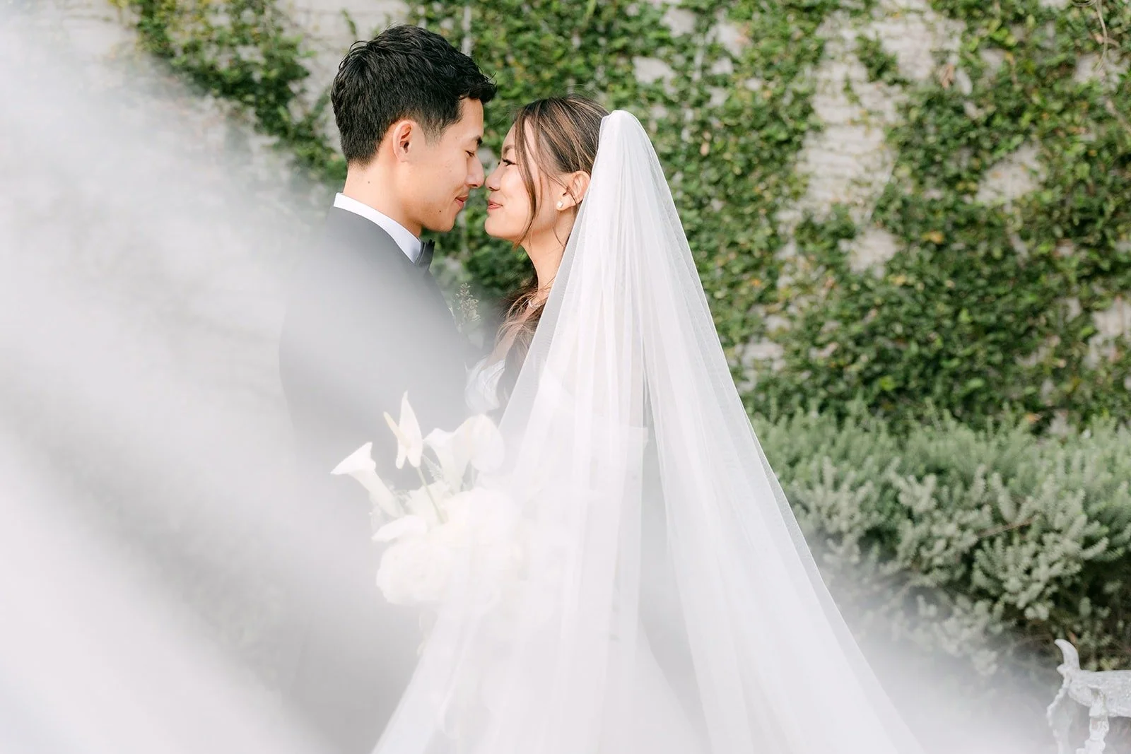 Jadee and Richard nose to nose with her veil drifting across the frame at The Harper
