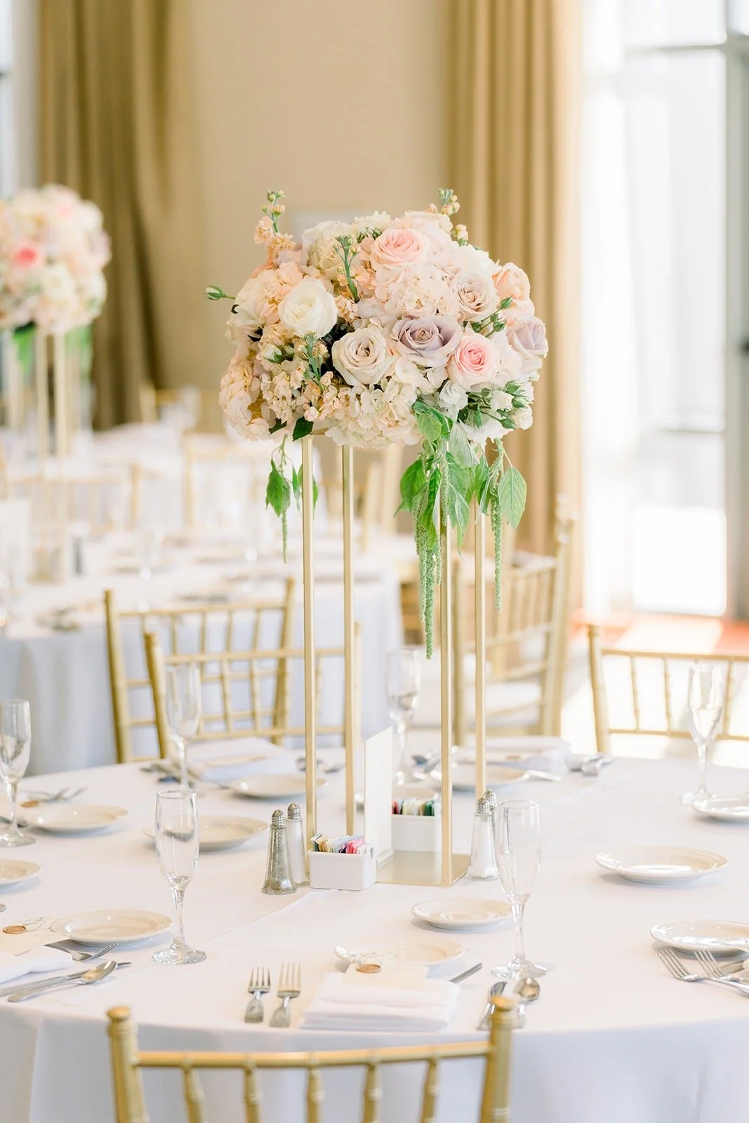 Guest table with crystal glasses and a pastel floral centerpiece
