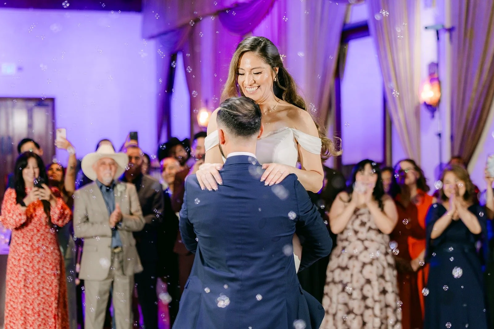 Danny lifting Mariana as guests cheer during the first dance