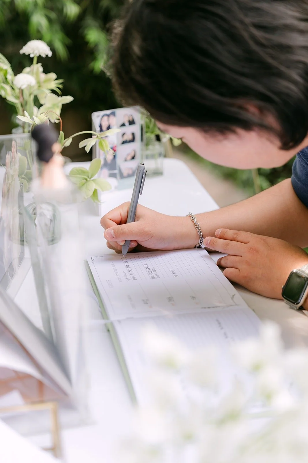 A guest signing the guest book at Franciscan Gardens