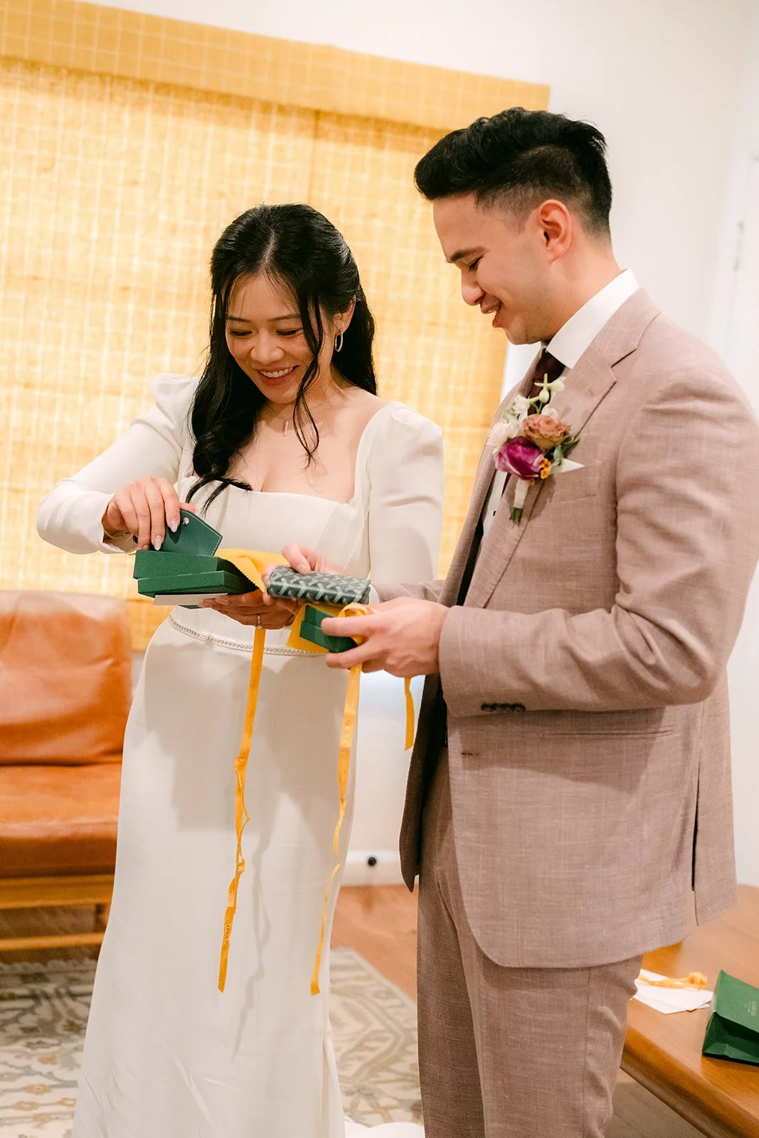 Denise opening a jewelry gift while Michael watches.