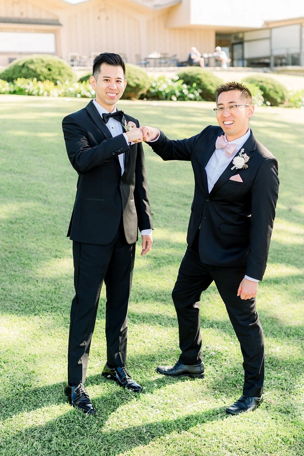 David and a groomsman joking around on the grass