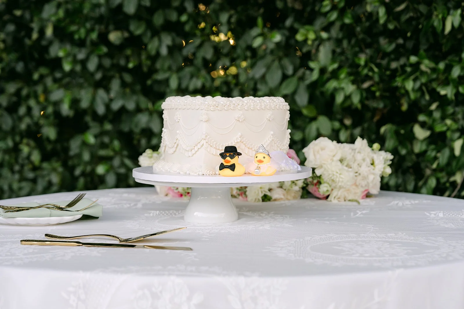 Nicole and Caryl's white wedding cake with a cake topper.