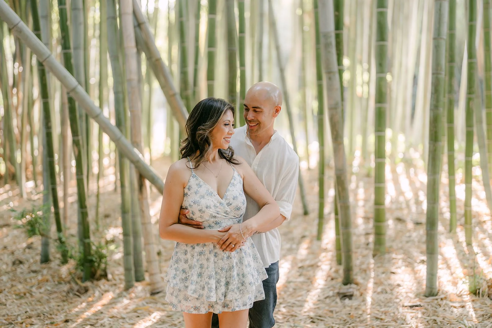 Francesca and Daniel embrace beneath a canopy of bamboo stalks.