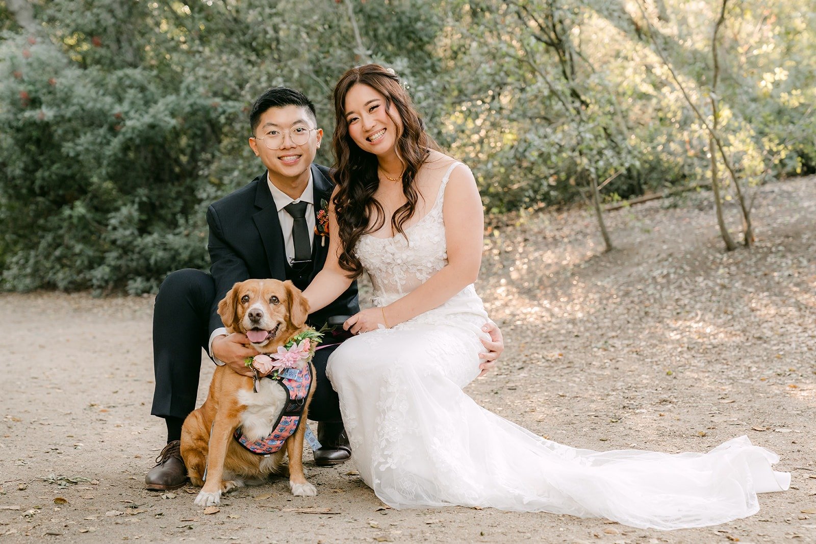 Shayna and Robert sit on the trail with a golden dog