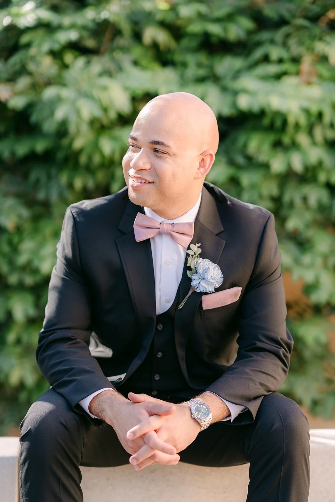Brandon sits in his tuxedo with a relaxed smile