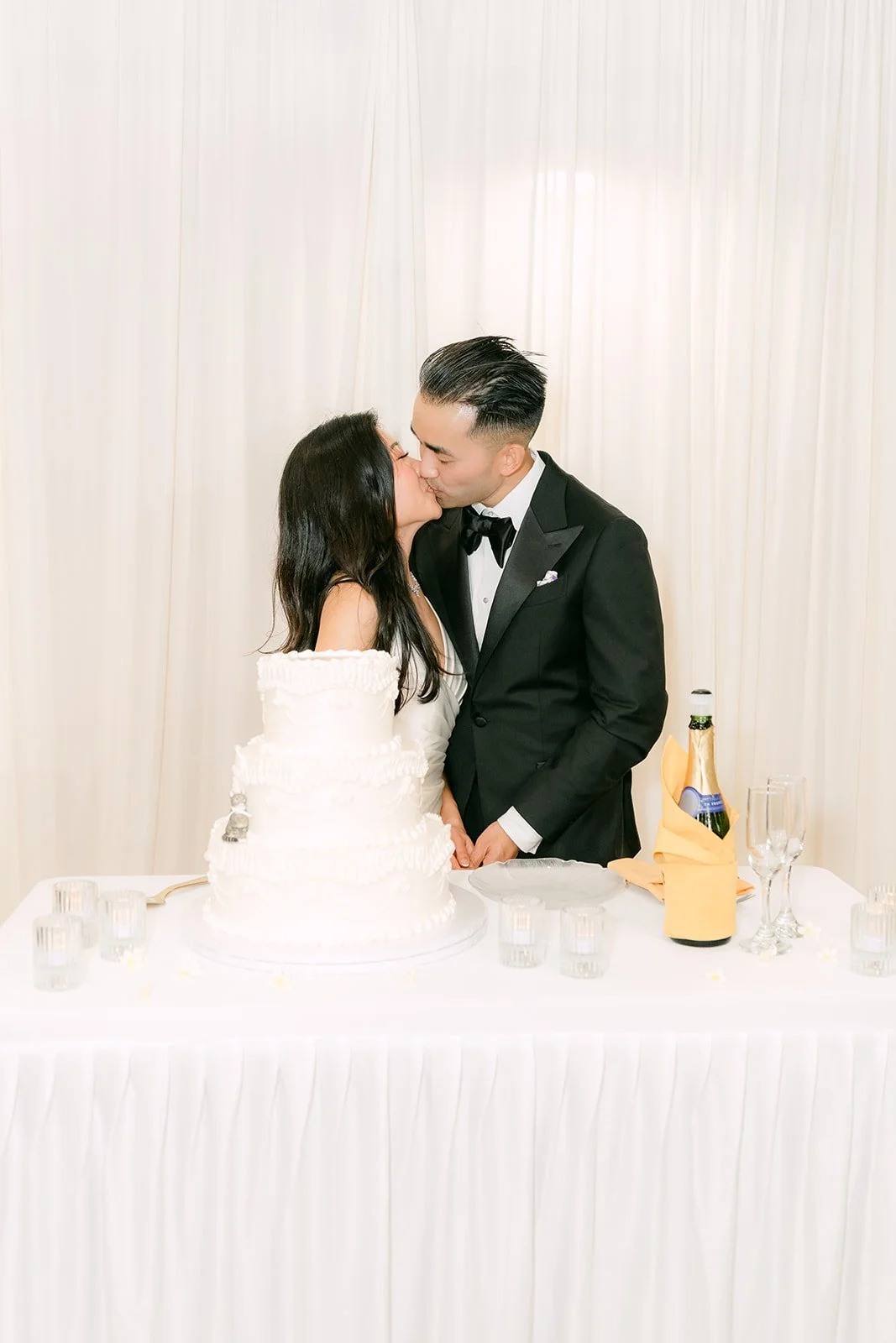 Kim and Vincent kissing at the cake table