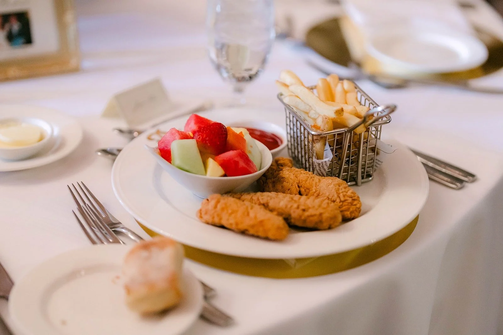 A plate of fried chicken and fresh fruit at the reception